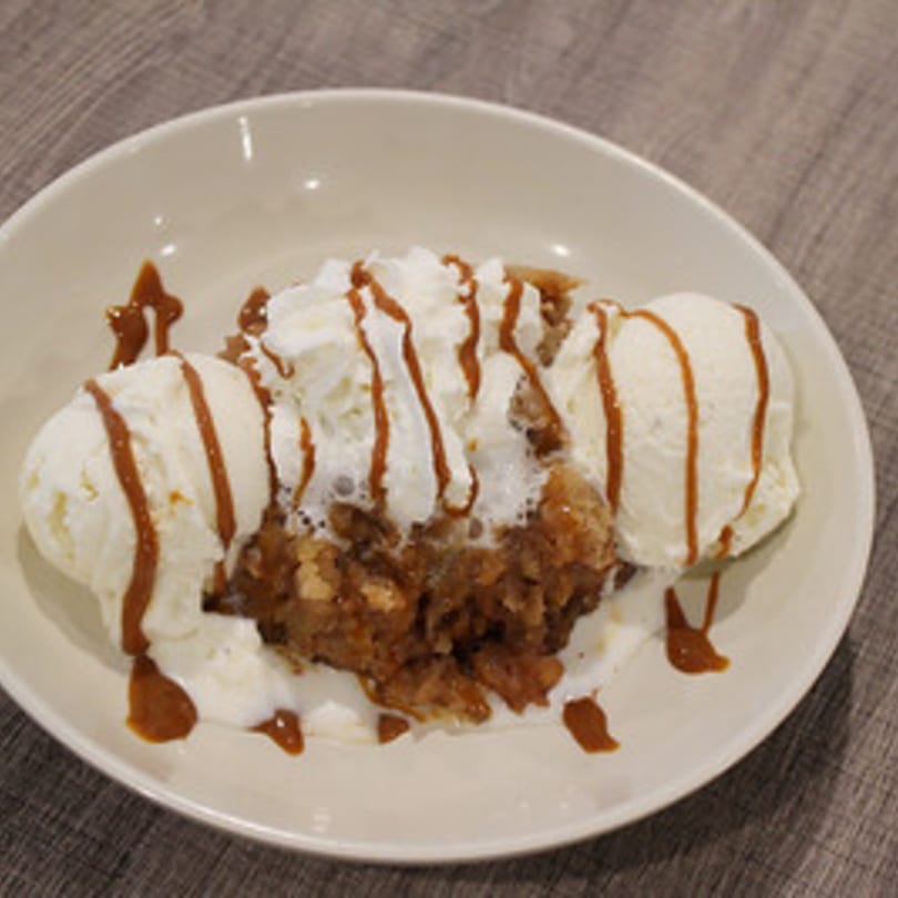 Marco Pizzeria's apple crumble dessert with vanilla ice cream, whipped cream, and caramel drizzle.