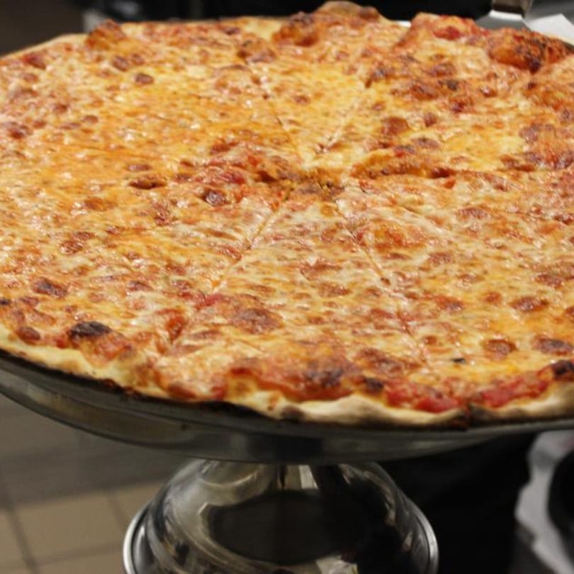 A large, freshly baked cheese pizza from Marco Pizzeria, sliced and ready to serve.