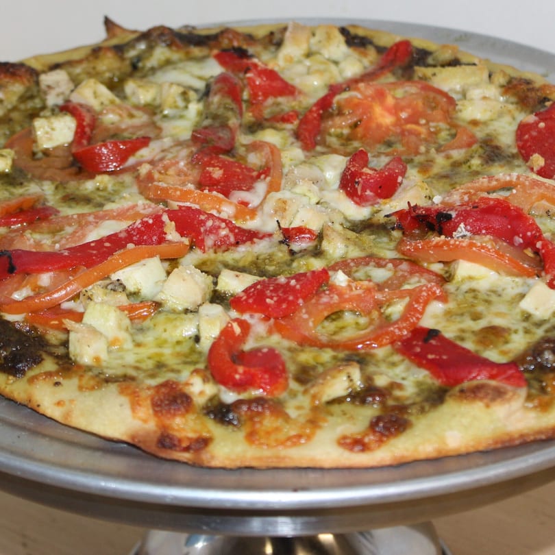 Marco Pizzeria's pesto pizza with chicken, red peppers, and tomatoes on a metal tray.