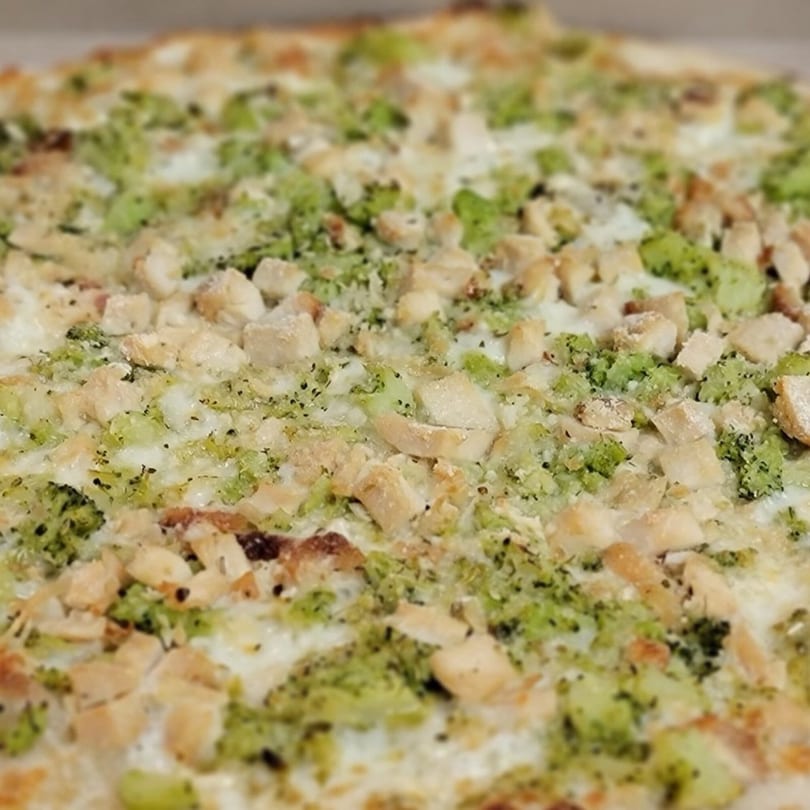 Close-up of a Marco Pizzeria white pizza topped with chicken, broccoli, and cheese.